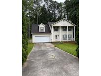 Charming two-story home with classic curb appeal, white garage door and pillar-supported porch at 2983 Trotters View Way, Snellville, GA 30039
