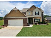 Charming two-story home featuring a well-manicured lawn and attached two-car garage at 609 Turnbill Dr, Mcdonough, GA 30252