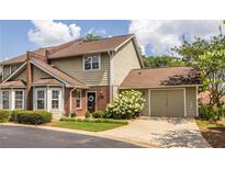 Charming two-story townhome featuring a brick facade, attached garage, and well-maintained landscaping at 104 Powell Cv, Decatur, GA 30030