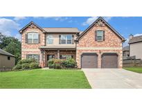 Beautiful two-story brick home with well-manicured lawn and attached two-car garage at 229 Traditions Drive Southeast Dr, Loganville, GA 30052