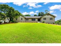 Charming brick home with a well-manicured front lawn and mature trees, creating a welcoming curb appeal at 4049 Northlake Creek Cv, Tucker, GA 30084