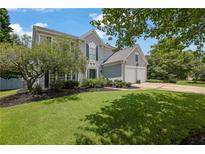 Charming two-story home with a manicured lawn, lush landscaping, and a two-car garage at 7325 Brookwood Way, Cumming, GA 30041