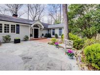 Charming home with a stone patio, lush landscaping, and a welcoming front entrance at 366 Blackland Nw Rd, Atlanta, GA 30342
