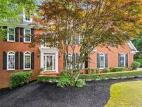 Charming brick home with manicured landscaping, black shutters, and a welcoming front entrance at 605 Linkside Hollow, Alpharetta, GA 30005