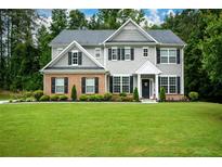 Charming two-story home with manicured lawn, gray siding, and brick accents, offering timeless curb appeal at 325 Paces Dr, Lithia Springs, GA 30122