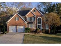 Charming two-story brick home with a two-car garage, manicured lawn, and mature landscaping at 4157 Berkeley Nw Lndg, Kennesaw, GA 30144