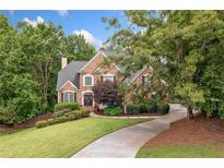 Charming brick home with a well-manicured lawn and a long driveway at 1335 Joy Ct, Suwanee, GA 30024
