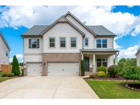 Charming two-story home featuring a three-car garage, brick accents, and manicured landscaping at 2039 West Hampton Dr, Canton, GA 30115