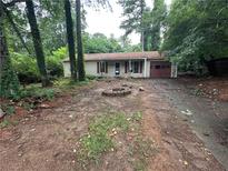 Single story home with lawn needing love and prominent fire pit feature at 2612 Ramblewood Ct, Acworth, GA 30102