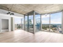 Bright living room featuring hardwood floors, ceiling fan, and floor-to-ceiling windows with a city view at 3324 Peachtree Ne Rd # 2518, Atlanta, GA 30326