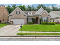 Charming brick home with a well-manicured lawn and a two-car garage at 430 La Perla Dr, Sugar Hill, GA 30518