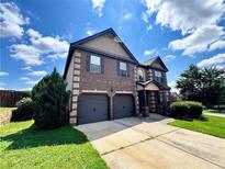 Charming two-story home with a brick facade, two-car garage and well-manicured lawn at 958 Nevis Way, Mcdonough, GA 30253