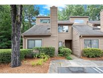 Charming townhouse exterior with landscaped front and classic architectural details and lush surroundings at 301 Parkaire Xing, Marietta, GA 30068