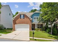 Charming two-story home featuring a brick facade, manicured lawn, and attached two car garage at 606 Lorimore Pass, Canton, GA 30115