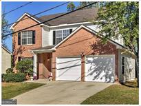 Charming brick and vinyl two-story home with a two-car garage and well-manicured front lawn at 1399 Cutters Mill Dr, Lithonia, GA 30058