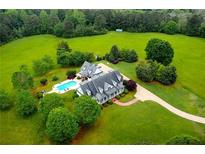 Expansive estate aerial view featuring a pool, circular driveway, and lush green landscaping at 1415 N Flat Rock Rd, Douglasville, GA 30134