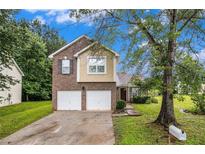 Charming two-story home featuring a brick and siding exterior, attached two-car garage, and well-maintained front lawn at 6177 Idlewood Cir, Lithonia, GA 30038