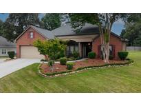 Charming brick home with manicured front yard and mature trees at 3262 Beech Hollow Ct, Loganville, GA 30052