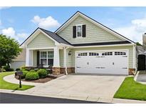 Charming one-story home with an attached two-car garage, well-maintained landscaping, and stone accents at 418 Thaxton Ln, Woodstock, GA 30188