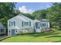 Charming home featuring light siding, blue shutters and door, plus lush green lawn and mature trees at 1279 Skyhaven Se Rd, Atlanta, GA 30316