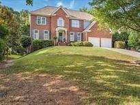 Two-story brick home featuring a manicured lawn and a two-car garage at 358 Woodbrook Crst, Canton, GA 30114