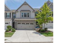 Charming townhouse with a two-car garage, neat landscaping, and an inviting facade at 1969 Lanier Harbor Pt, Buford, GA 30518