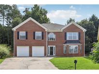 Charming two-story brick home featuring an attached two-car garage and well-manicured lawn at 2379 Fallbrook Ct, Duluth, GA 30096