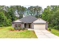 Charming single-story home featuring brick accents, a well-manicured lawn, and attached two car garage at 509 Grace Ln, Villa Rica, GA 30180