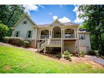 Charming two-story home with a welcoming front porch and a lush green lawn at 8040 Banks Mill Rd, Douglasville, GA 30135
