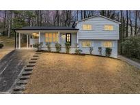 Charming two-story home featuring a light-colored exterior with a covered porch and a beautifully landscaped front yard at 847 Magna Carta Nw Dr, Atlanta, GA 30318