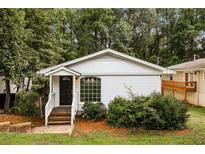 Charming single-story home with white siding, a black front door, and a well-maintained, tree-lined yard at 1947 Main St, Atlanta, GA 30318