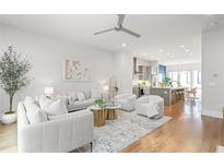 Bright living room featuring hardwood floors, modern furnishings, and an open concept design to the kitchen at 332 Gibson Se St, Atlanta, GA 30316