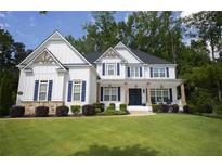 Charming two-story home with white siding, navy shutters, covered porch, and lush green lawn at 1895 Henley Way, Alpharetta, GA 30009