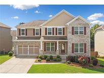 Traditional two-story home featuring a well-manicured lawn, brick accents, and charming curb appeal at 522 Spring View Dr, Woodstock, GA 30188
