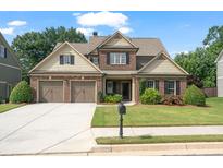 Charming two-story home with a well-manicured lawn, brick facade, and a two-car garage on a sunny day at 452 Rockford Pass, Marietta, GA 30064