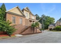 Charming brick home featuring a stone accent, landscaped front yard and a welcoming entrance with stairs at 1711 Summit Glen Ln, Atlanta, GA 30329