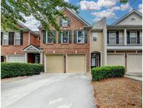 Charming brick townhome with a two-car garage and well-maintained landscaping at 2515 Gadsen Walk, Duluth, GA 30097