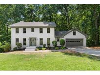 Charming two-story home with a manicured lawn and a two car garage surrounded by mature trees at 5236 Forest Brook Pkwy, Marietta, GA 30068