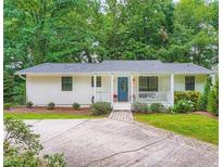 Charming single-story home with a blue front door, white trim, and lush green landscaping at 3841 Admiral Dr, Atlanta, GA 30341