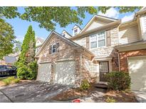 Charming townhome featuring a stone facade, two-car garage, and well-maintained landscaping at 1804 Evadale Ct # 1, Mableton, GA 30126