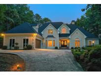 Stately home with manicured landscaping, circular driveway, and exterior lighting creates a welcoming ambiance at 2885 Coles Way, Atlanta, GA 30350