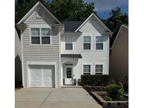 Charming two-story home featuring a one-car garage, lush landscaping, and a welcoming front entrance at 443 Marsh Lake Rd, Lawrenceville, GA 30045