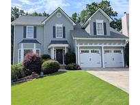 Charming two-story home featuring a well-manicured lawn and a convenient two-car garage at 1581 Shetland Pony Ct, Suwanee, GA 30024