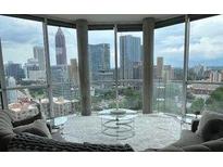 Modern living room featuring floor-to-ceiling windows showcasing city skyline views at 285 Centennial Olympic Park Nw Dr # 1905, Atlanta, GA 30339