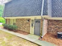Charming brick townhome featuring a gray front door and well-maintained landscaping at 1128 Hampton Way, Atlanta, GA 30324