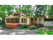 Charming home with a brick foundation, unique architecture, and a cozy screened porch at 8805 Lake Dr, Snellville, GA 30039