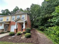 Charming townhome featuring a brick facade, well-kept landscaping, and an attached single car garage at 1788 Arbor Gate Dr # 1505, Lawrenceville, GA 30044