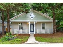 Charming bungalow features a quaint front porch, fresh paint, and mature trees at 4594 Poplar Rd, Pine Lake, GA 30072