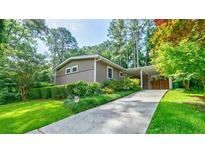 Charming exterior view with a long driveway, well-manicured lawn, and lush landscaping at 3027 Vista Brook Dr, Decatur, GA 30033
