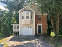 Charming home featuring a brick accent, attached garage, and a classic black front door at 5000 Saxony Ct, Stone Mountain, GA 30083